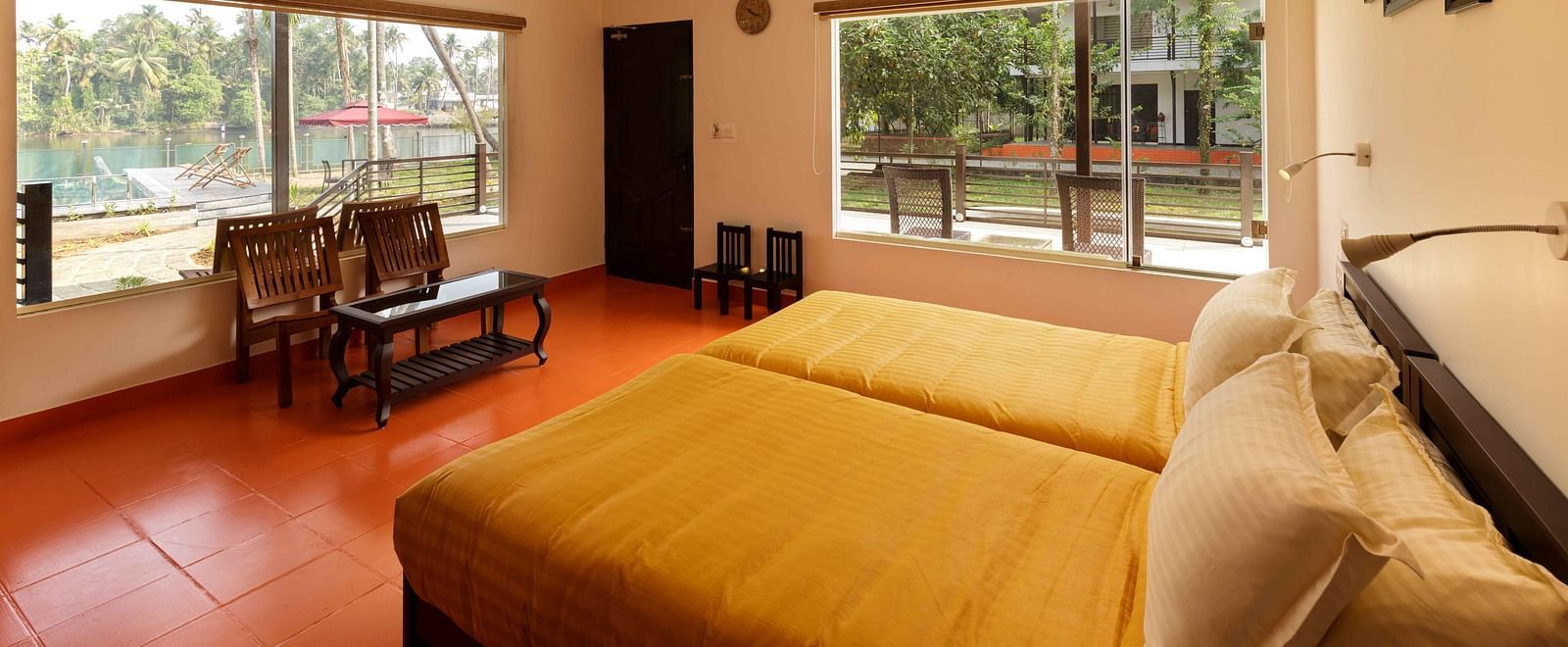 A bedroom with two beds, a seating area by a window, and ceiling fans.
