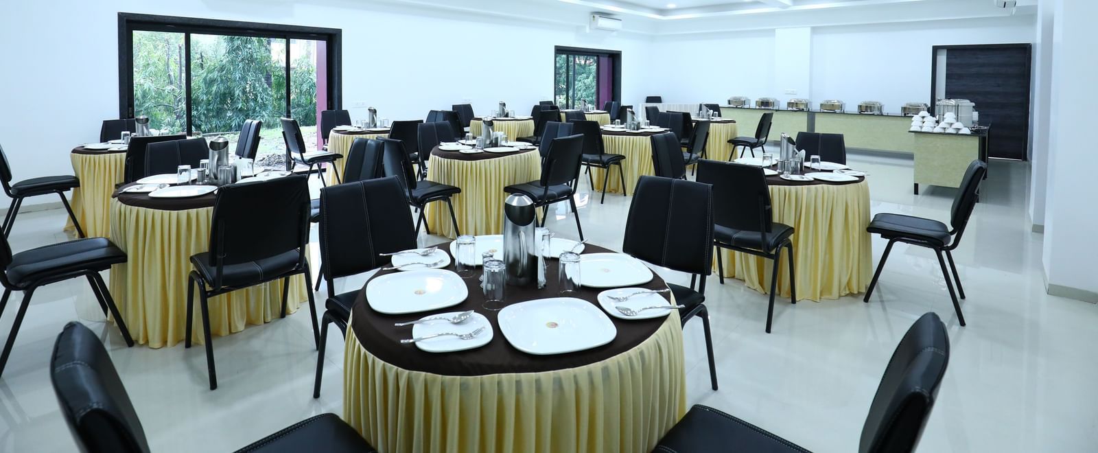 A well-lit dining space at Imperial Grande, featuring a clustered seating arrangement and windows offering a view of the outdoors.