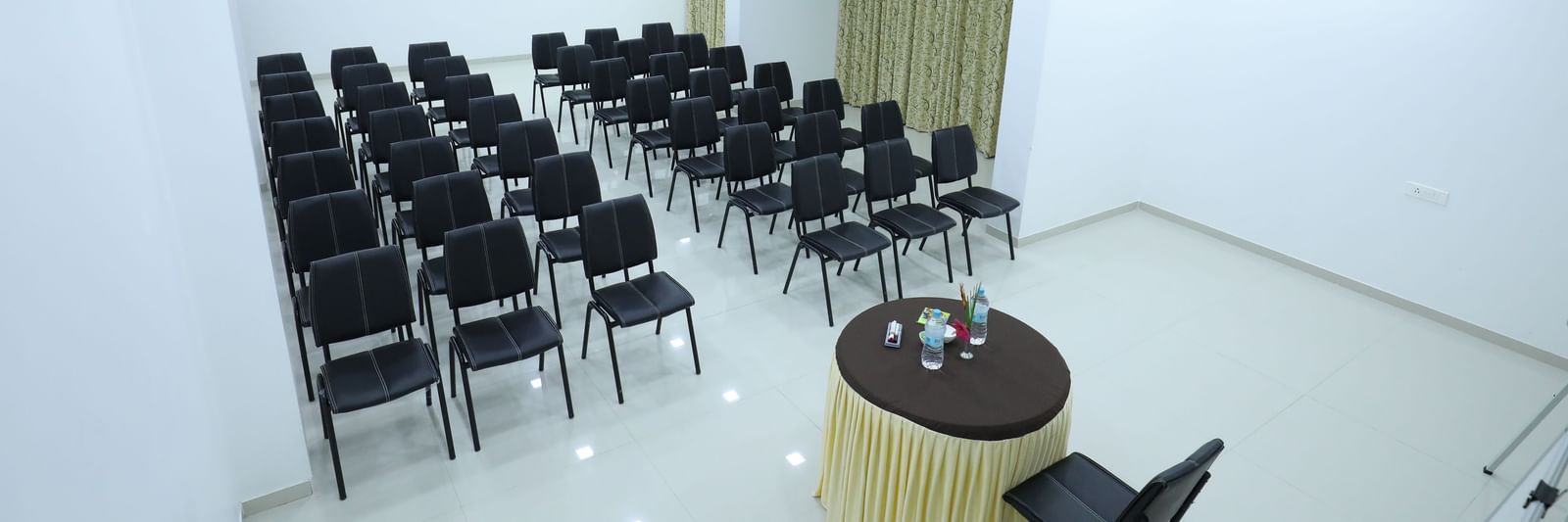A large meeting room at Imperial Grande with a round table and chairs arranged neatly.