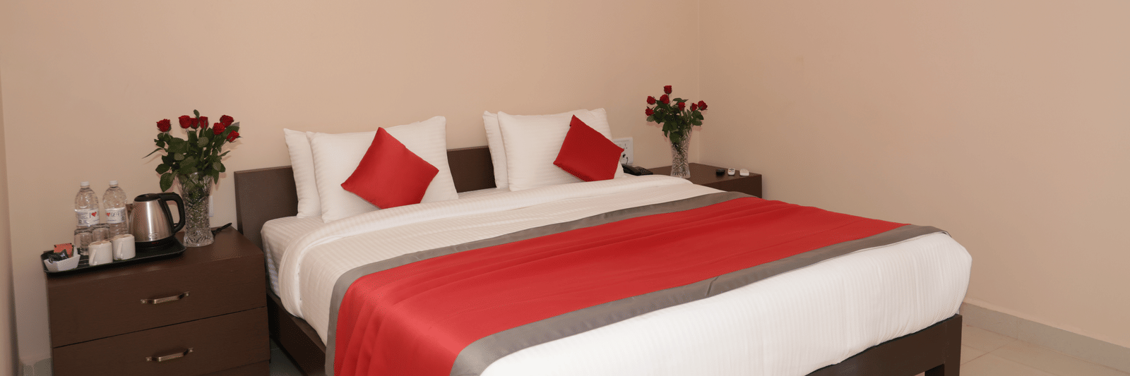 A bedroom at Nazri The Verda Hotel, Arambol, featuring a bed with cushions, bedside tables, and wall decorations.