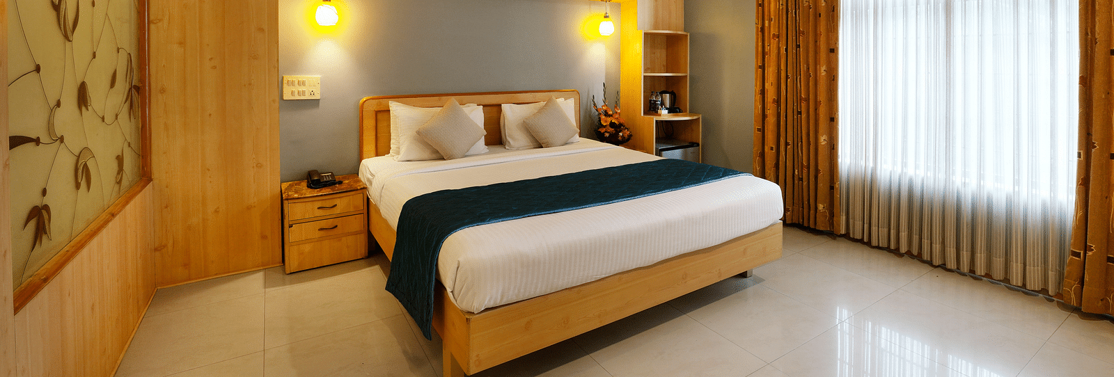 A spacious Suite with a king size bed and large windows - Cross Roads Inn, Bengaluru