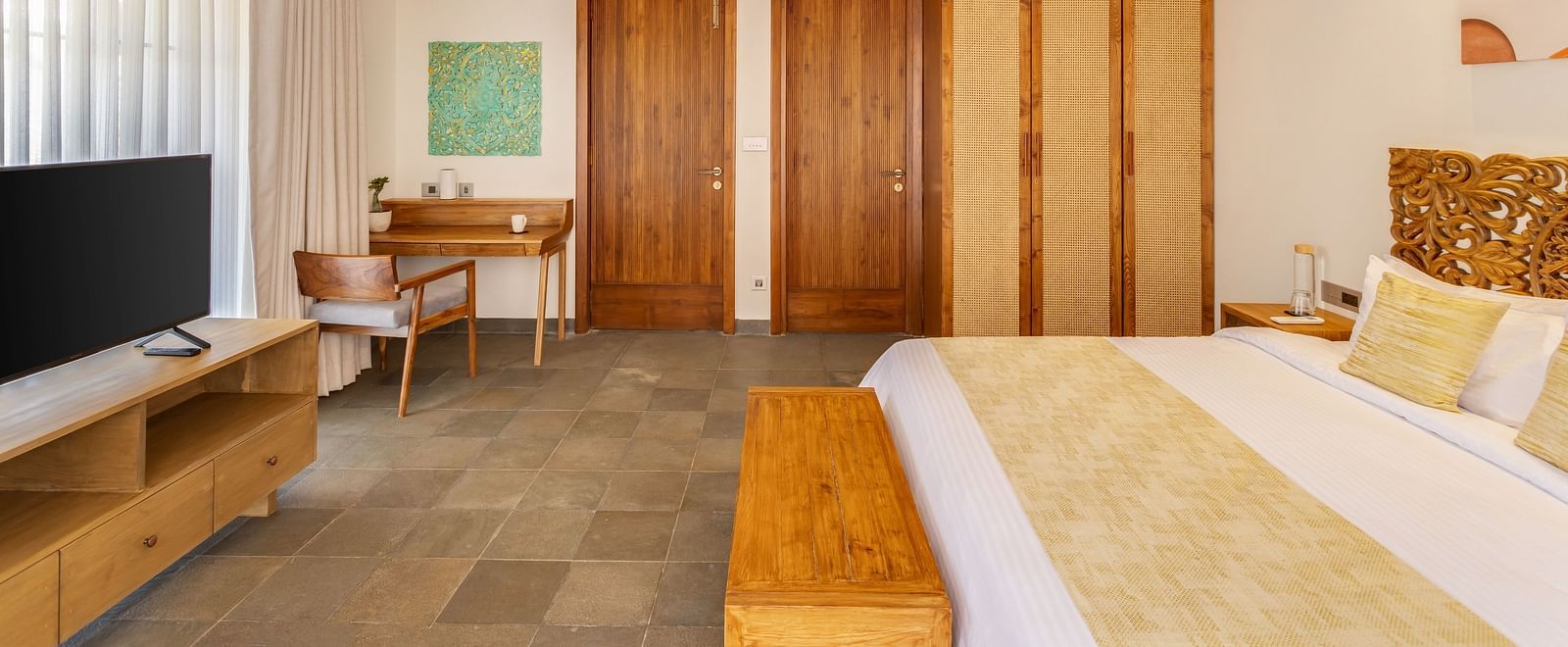 A spacious bedroom featuring a king-sized bed, wooden furnishings, and bright natural light streaming through the windows - BluSalzz Villas - Alocassia, Anjuna