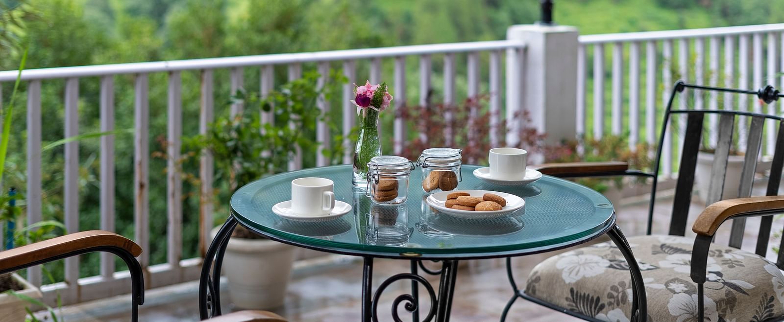 Scenic outdoor tea setup with pastries overlooking lush green hills at BluSalzz Collection - Suvaasa Resort, Ramgarh.