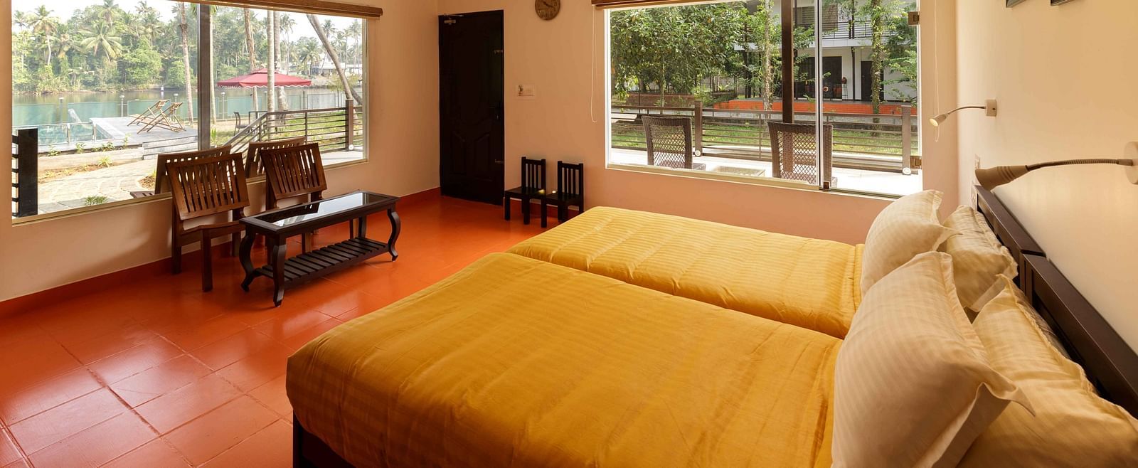 A bedroom with two beds, a seating area by a window, and ceiling fans.