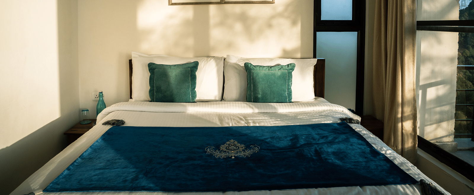 A bedroom with sunlight streaming through the windows at BluSalzz Escapade Resort, Lansdowne.