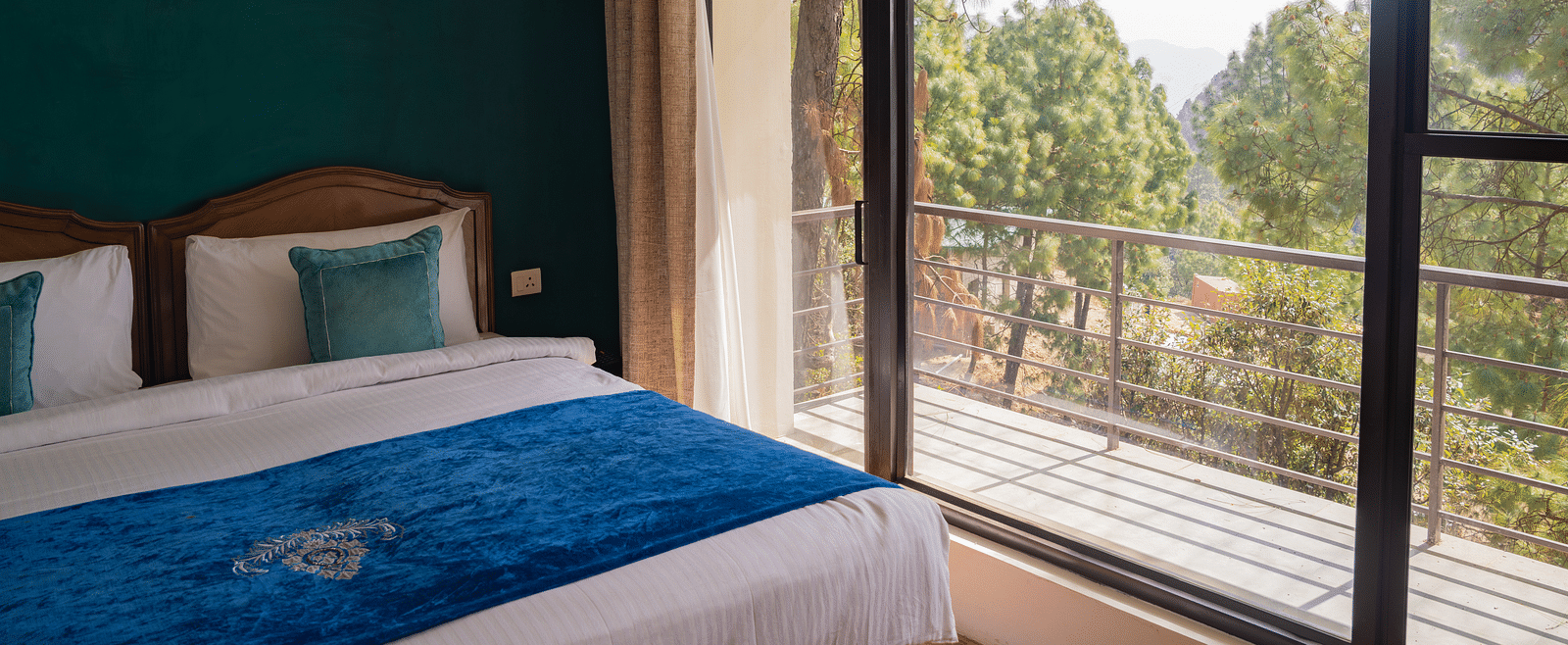 A bedroom with a light hanging from the ceiling and a balcony at BluSalzz Escapade Resort, Lansdowne