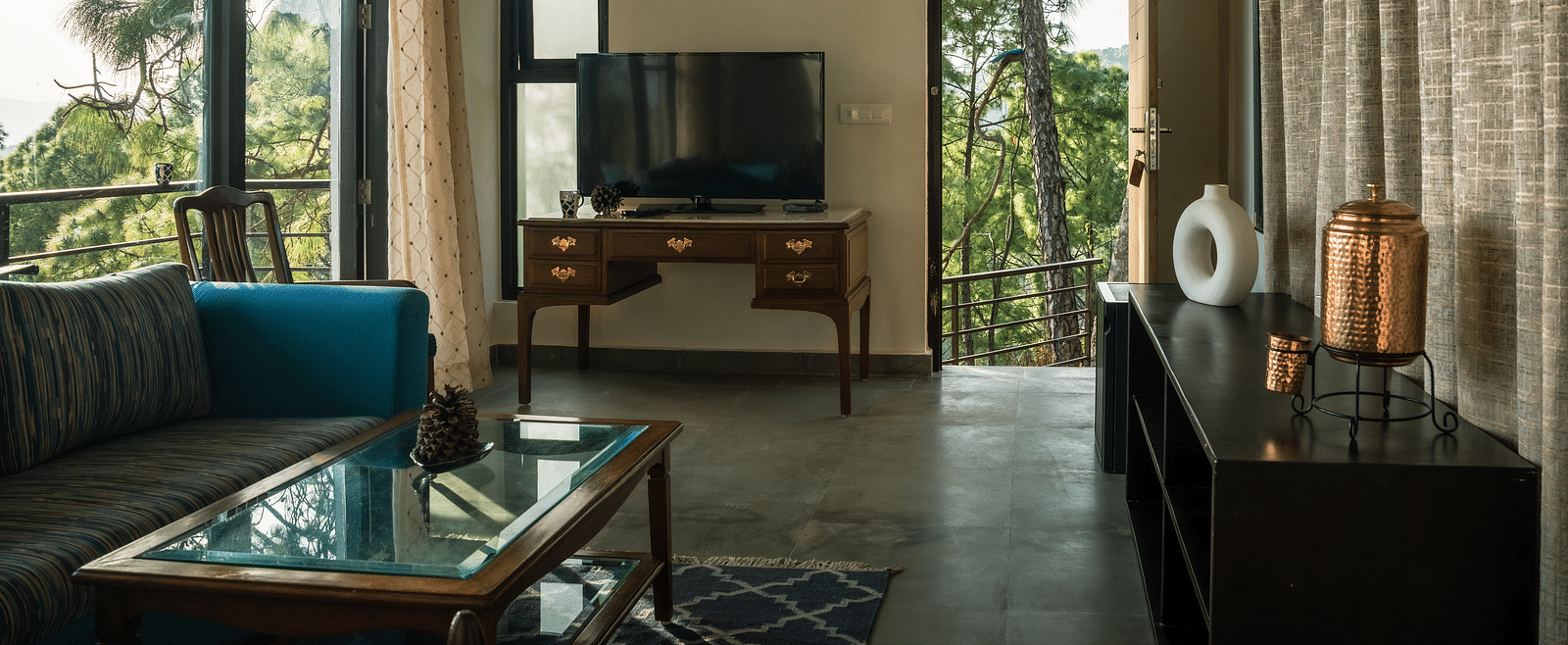 A living room featuring sofas, a table, and a television at BluSalzz Escapade Resort, Lansdowne