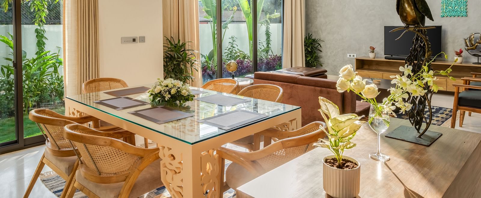 A contemporary dining area featuring a large wooden table, stylish chairs, and abundant natural light streaming through the windows.