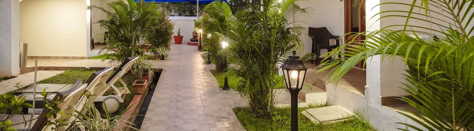 Paved garden pathway lined with plants and traditional lanterns at The Verda de Miranda Resort.
