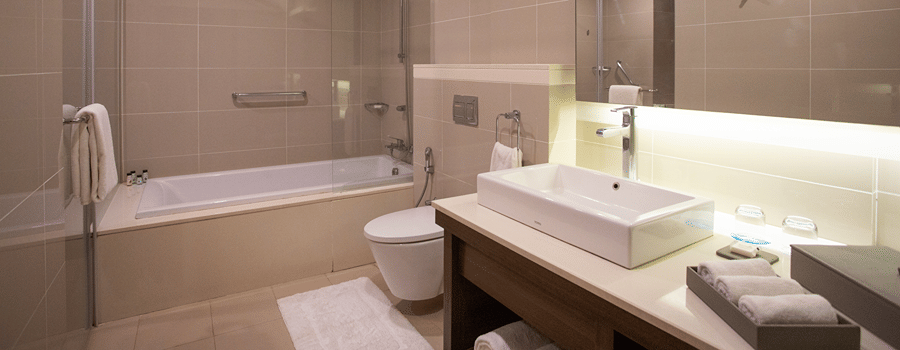 A spacious bathroom featuring a wash basin area and a large bathtub at The Residency Towers Rameswaram