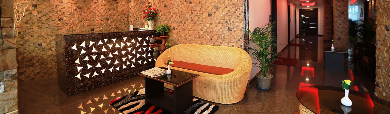 A reception area with ratan furnitures and a front desk at Parampara Residency, Kushalnagar.