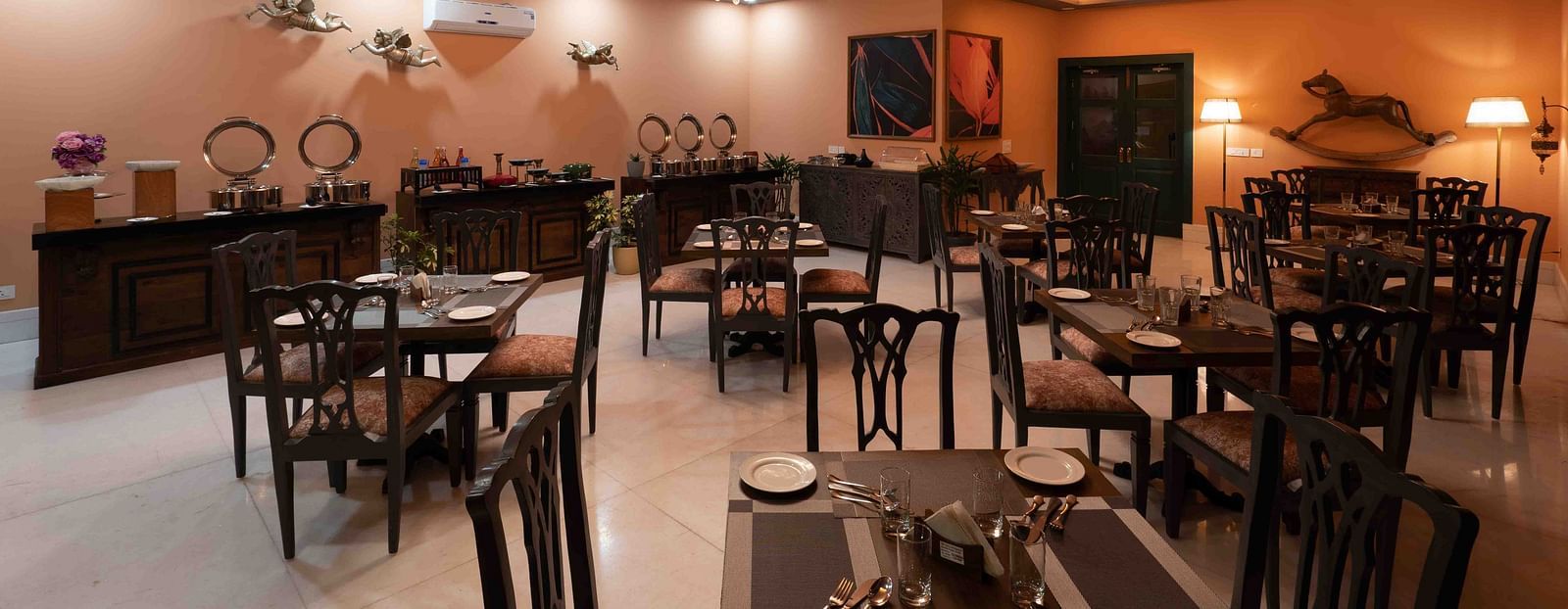 An image of spacious restaurant at atman, dharamshala with high ceilings and large windows, offering a bright and airy atmosphere.