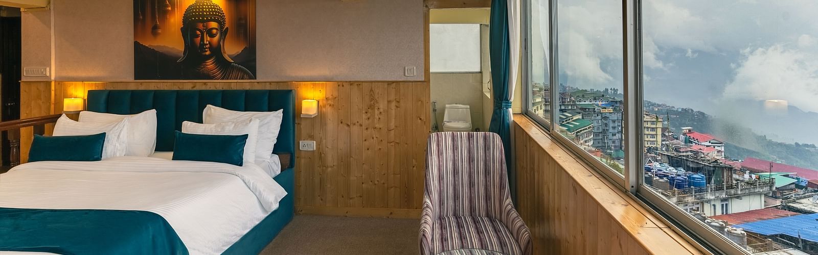 Image of a room with bed and seating area and large glass at Seven Seas