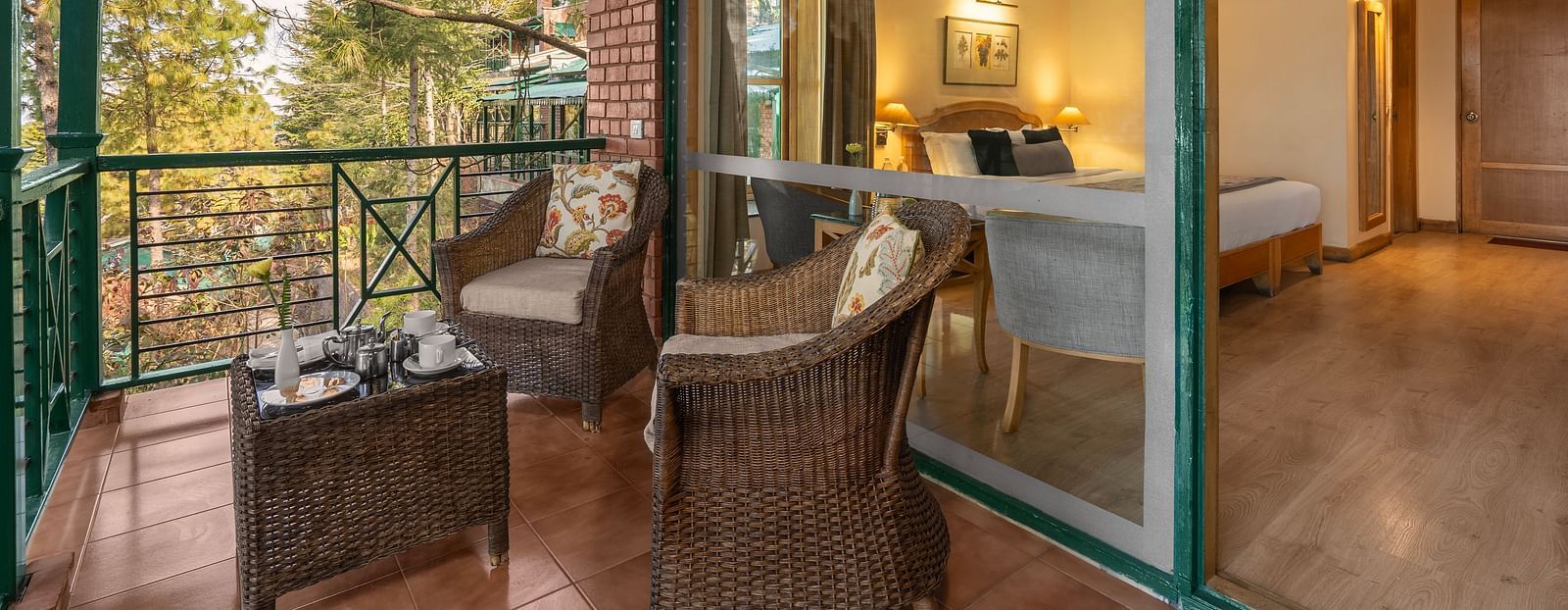 Superior Cottage Valley View room sirring area with woodren chairs and table at - Baikunth Resort, Kasauli  