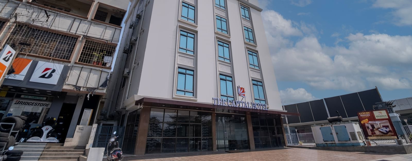 Angled exterior view of Swarna's The Capital highlighting its urban setting and stylish structure.