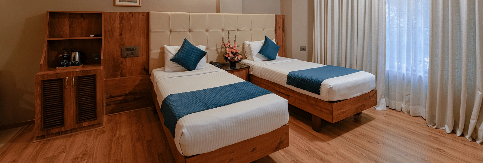 An image of our spacious Deluxe Room with twin beds and elegant lighting - Cross Roads Inn, Bengaluru
