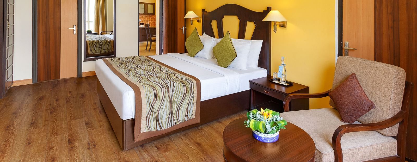 This image showcases a luxurious hotel room of aloha on the ganges, with a warm and inviting atmosphere. The room features a large king-size bed with a plush headboard and comfortable bedding.