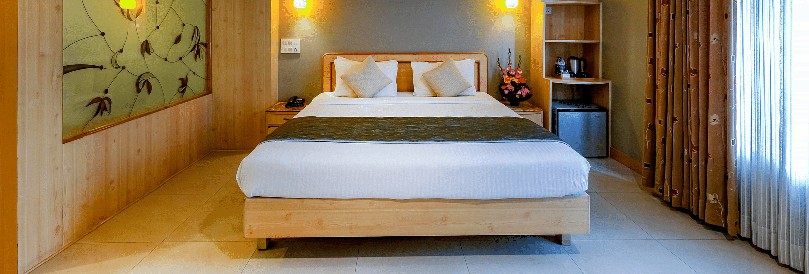 An elegant Suite with a stylish headboard and large bed - Cross Roads Inn, Bengaluru