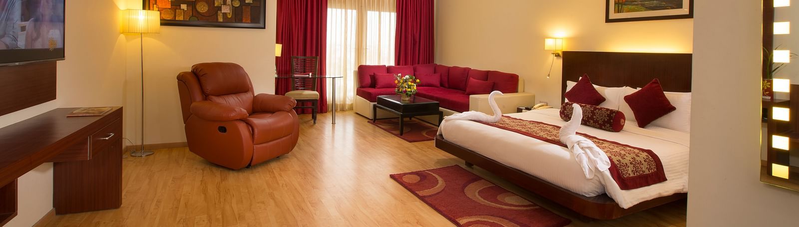 a view of Family Suite featuring a bed, a television and a recliner at Hotel Atithi - TGI Grand, Pondicherry