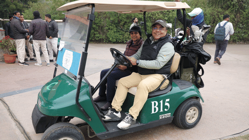 An image of two people riding a mini car to reach the gold course - Heritage Village Resorts & Spa
