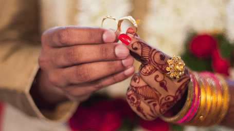 a bride and groom holding wedding rings together - polo floatel kolkata