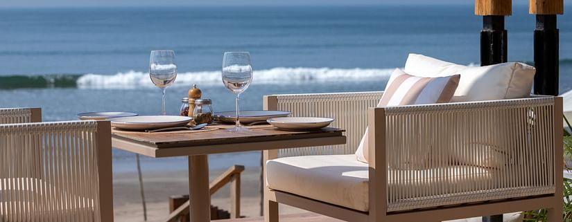 close up image of a chair with white cushion with a serene background of blue ocean