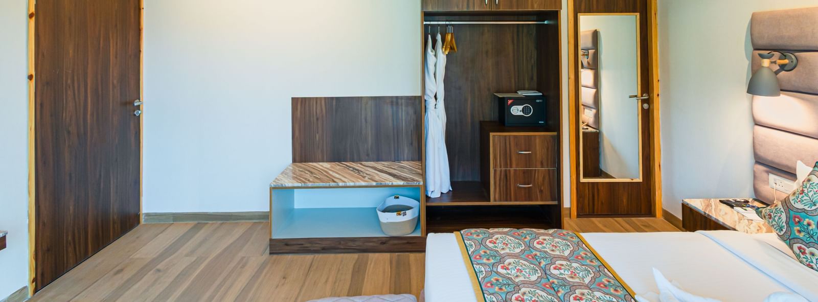 Sajjan Villa featuring a wardrobe, a bed, an AC, hanging lights from the ceilings, and a ceiling fan.