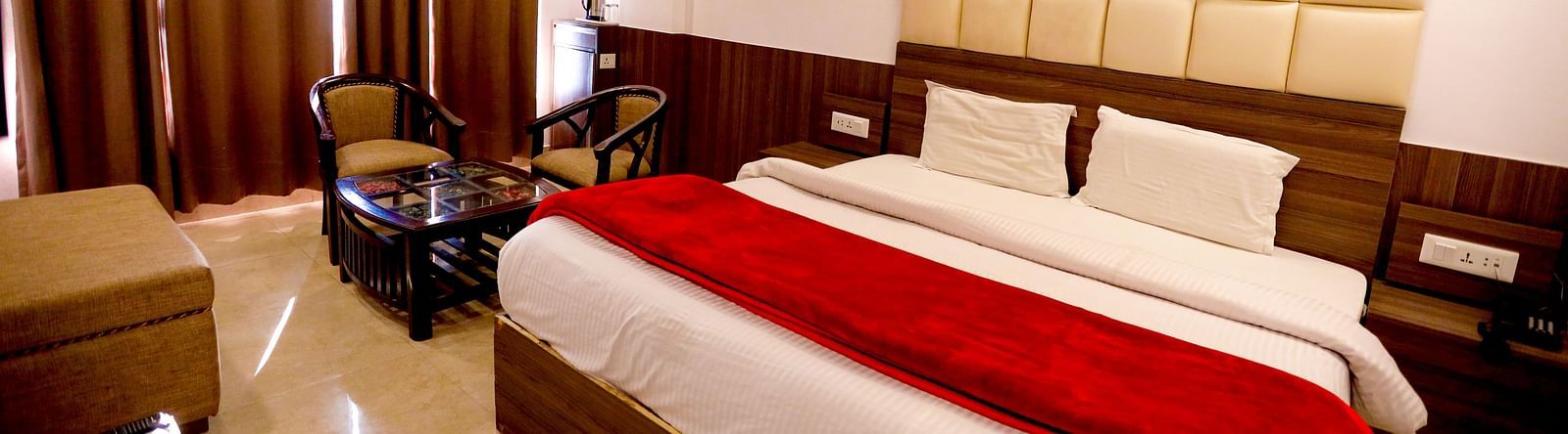 Image of a room with a bed and window on the side at Amara Hill Queen, Mussoorie.