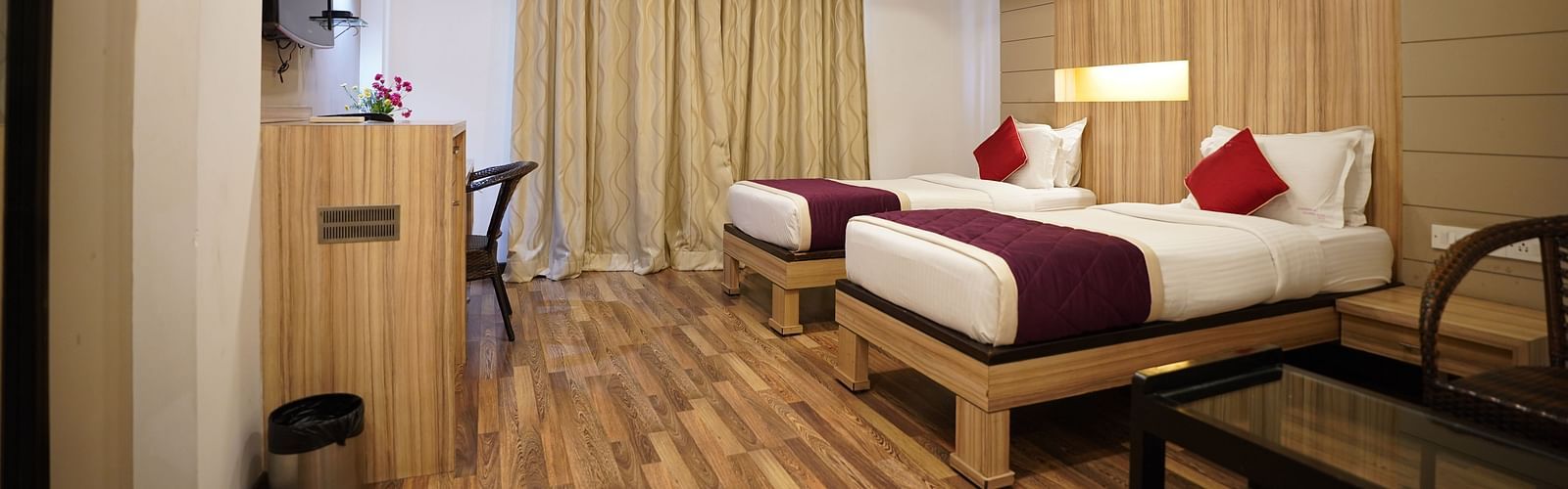 an image of a executive deluxe room with twin beds and a television  