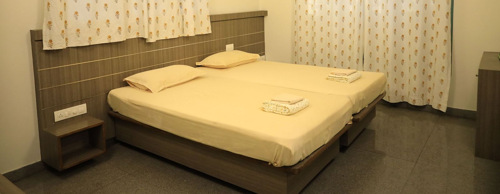 A shot of the bedroom with a bed, nightstands, and curtains.
