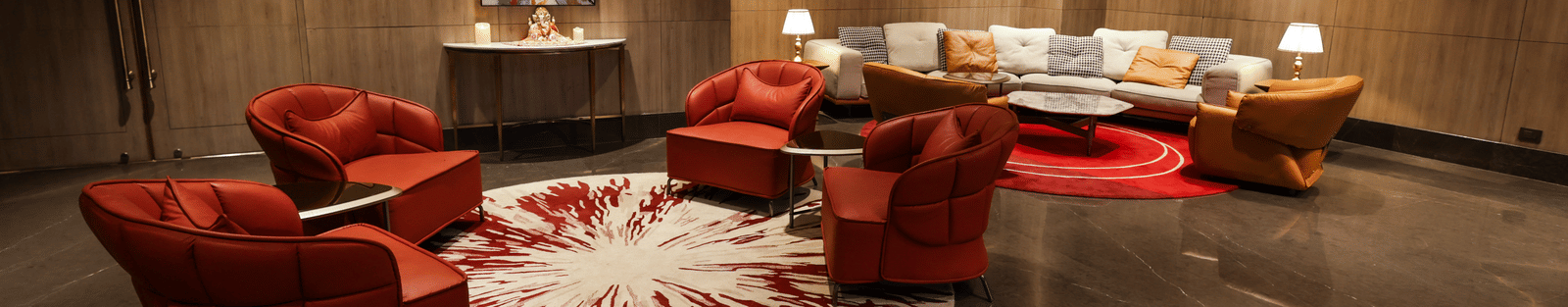 Stylish lounge area with red armchairs and elegant lighting at Ramada by Wyndham Sonipat Murthal