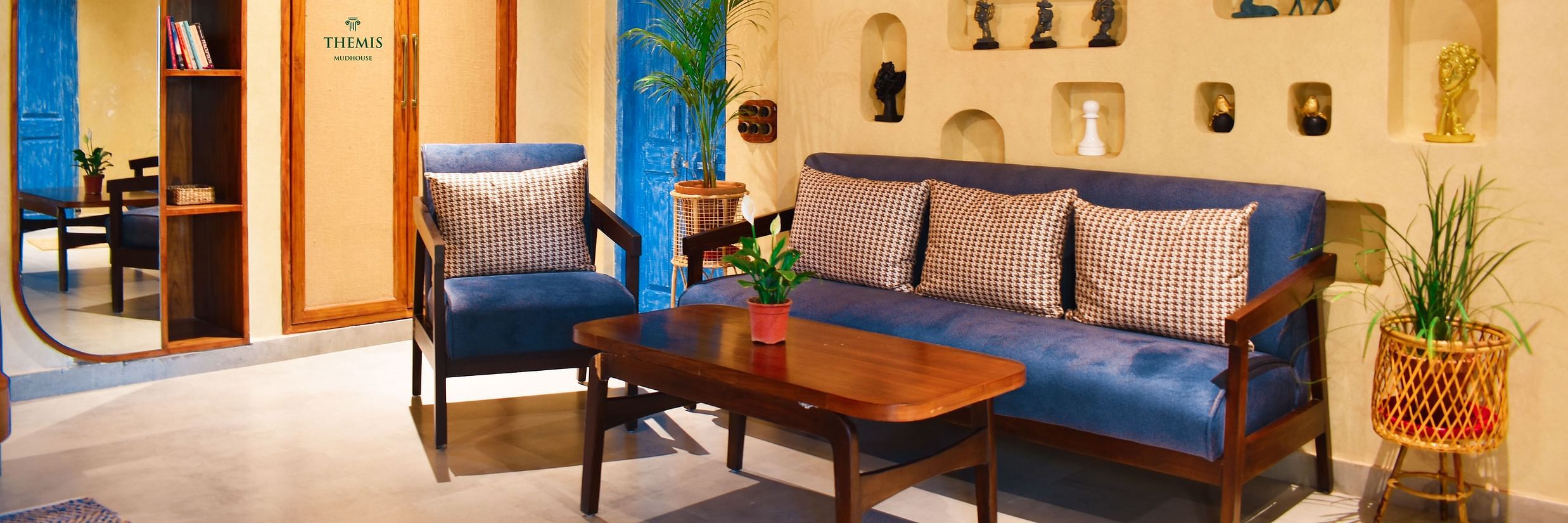interior of Classic Villas arrayed with a sofa, trinkets and a lamp hanging from the ceiling at Themis Mudhouse - A Nature's Retreat Resort & Wellness