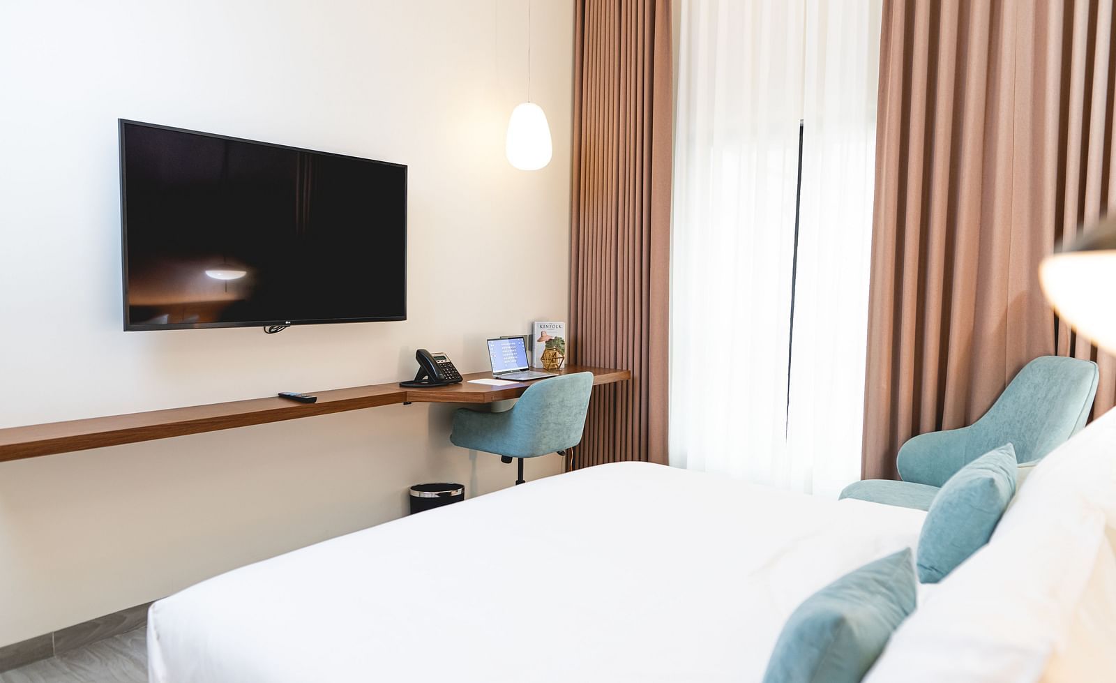 image of the standard room at Kertel Suites, kinshasa featuring a wall mounted television placed opposite to a double bed
