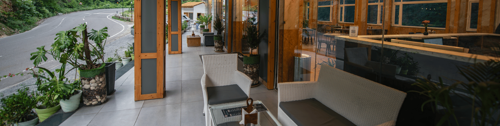 An outside sitting area of the restaurant at The Tattva Devaprayag featuring a couch and a coffee table.