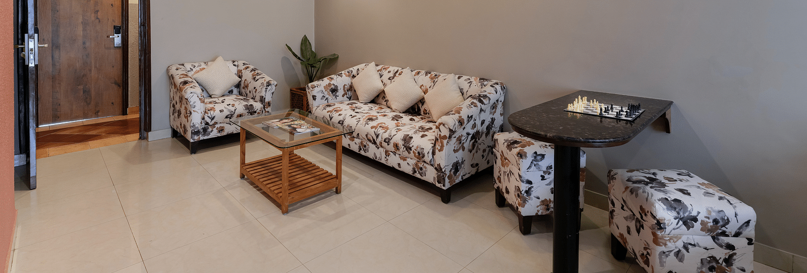 A spacious seating area in our Suite with a patterned sofa set - Cross Roads Inn, Bengaluru