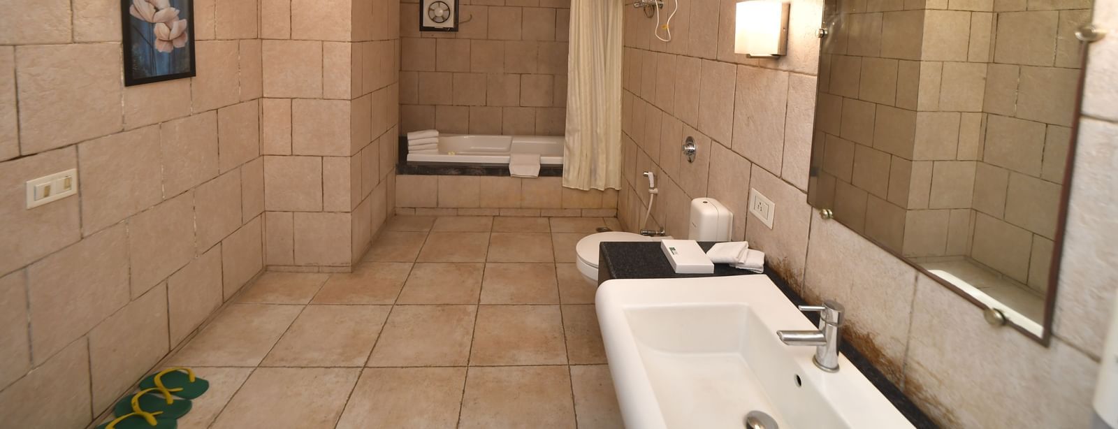 A modern bathroom showcases twin sinks, a large mirror, and a bathtub or shower area | Green Villa