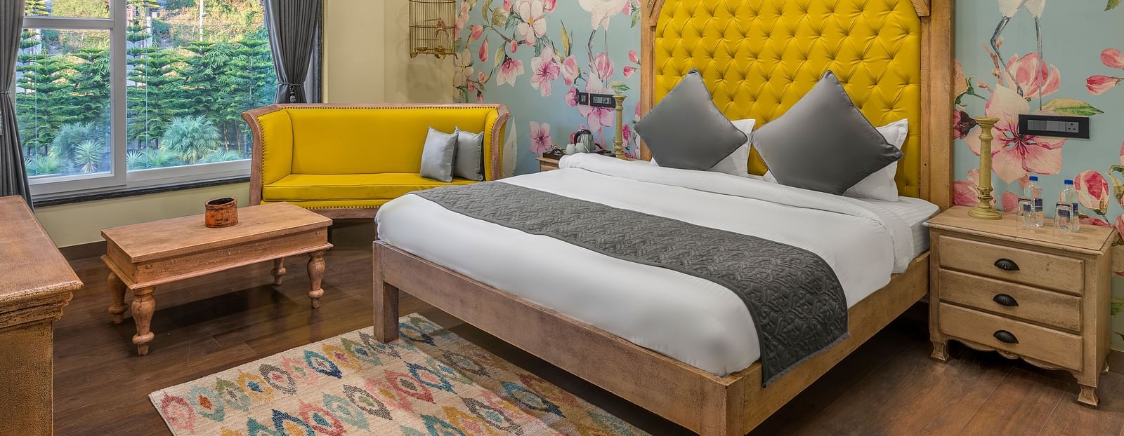 a bedroom with a large bed with a headrest and a sofa beside it - Atman, Dharamshala
