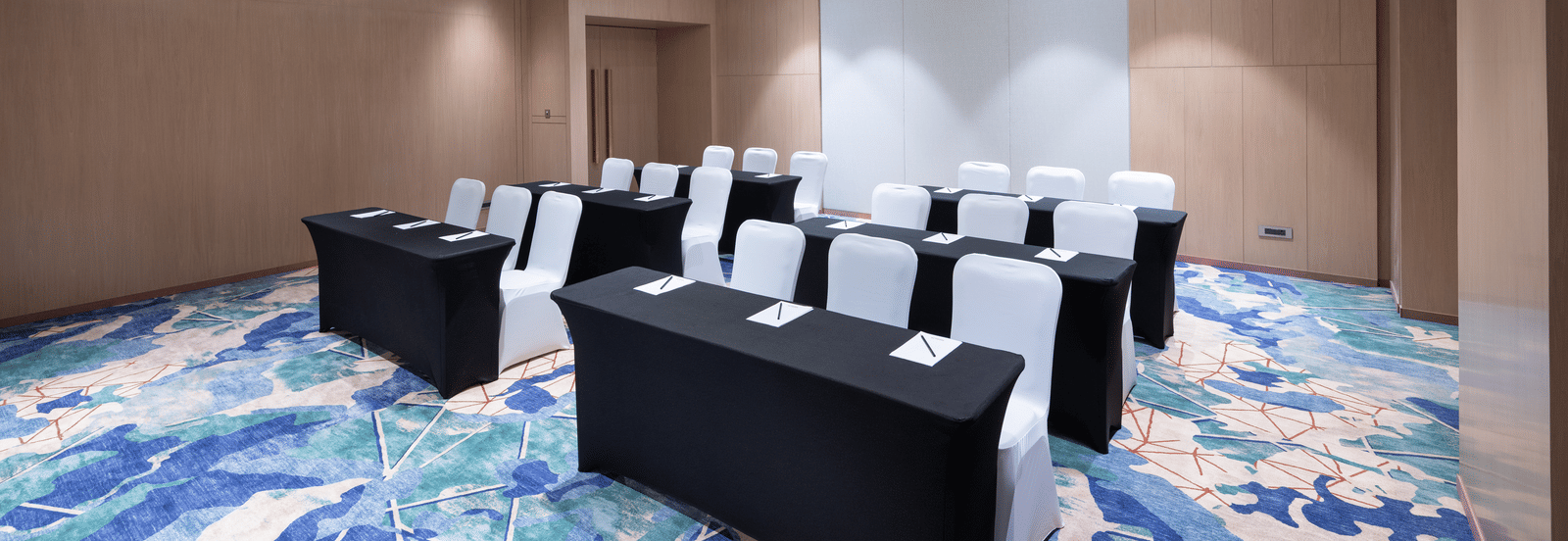 Spacious room with modern U-shaped table arrangement at Merlis Hotel, Coimbatore.