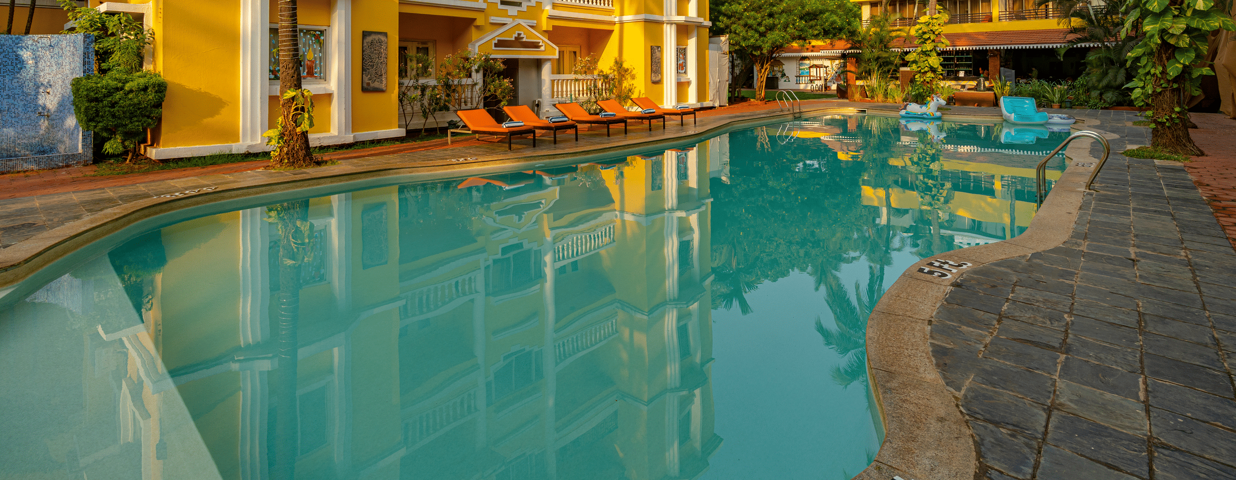 The pool of the hotel surrounded by the hotel building.