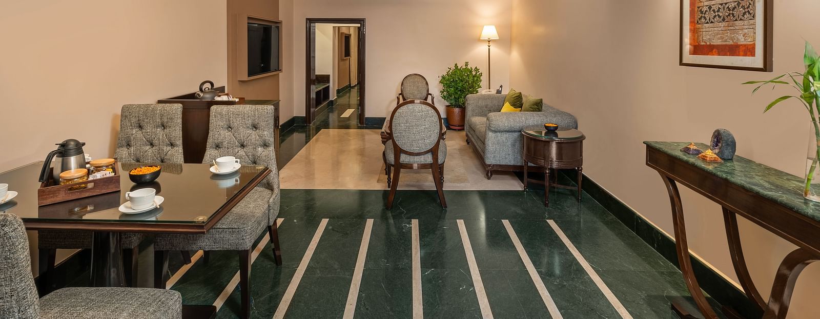 Maharaja Suite Living Room with a table set for dining and sofas for sitting - Ganga Lahari, Haridwar