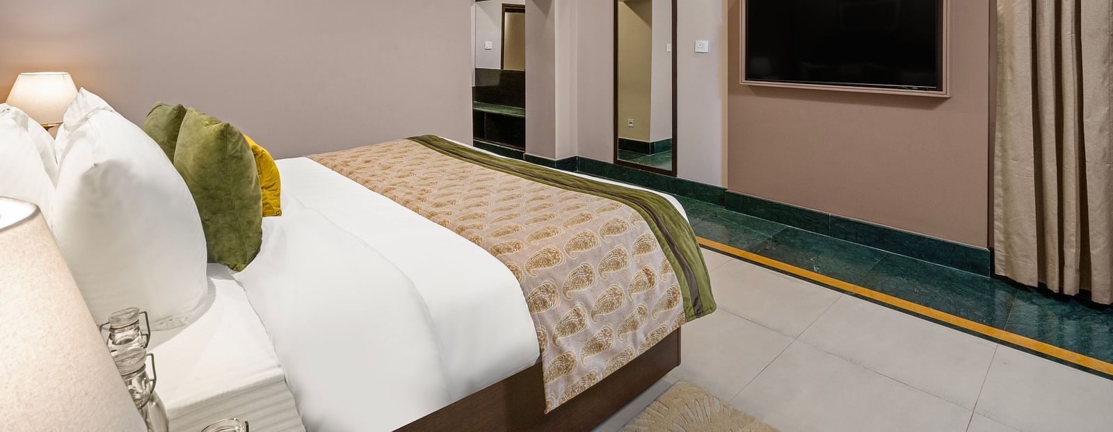 Maharaja Suite Room with a large bed facing a television and an air-conditioner - Ganga Lahari, Haridwar