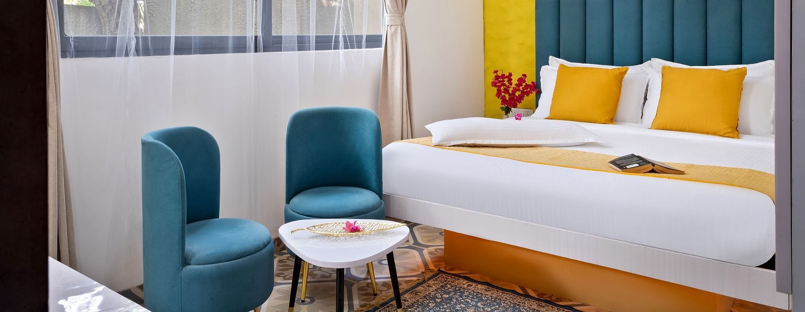 Bedroom featuring artistic decor, bold colours, and a serene outdoor view.