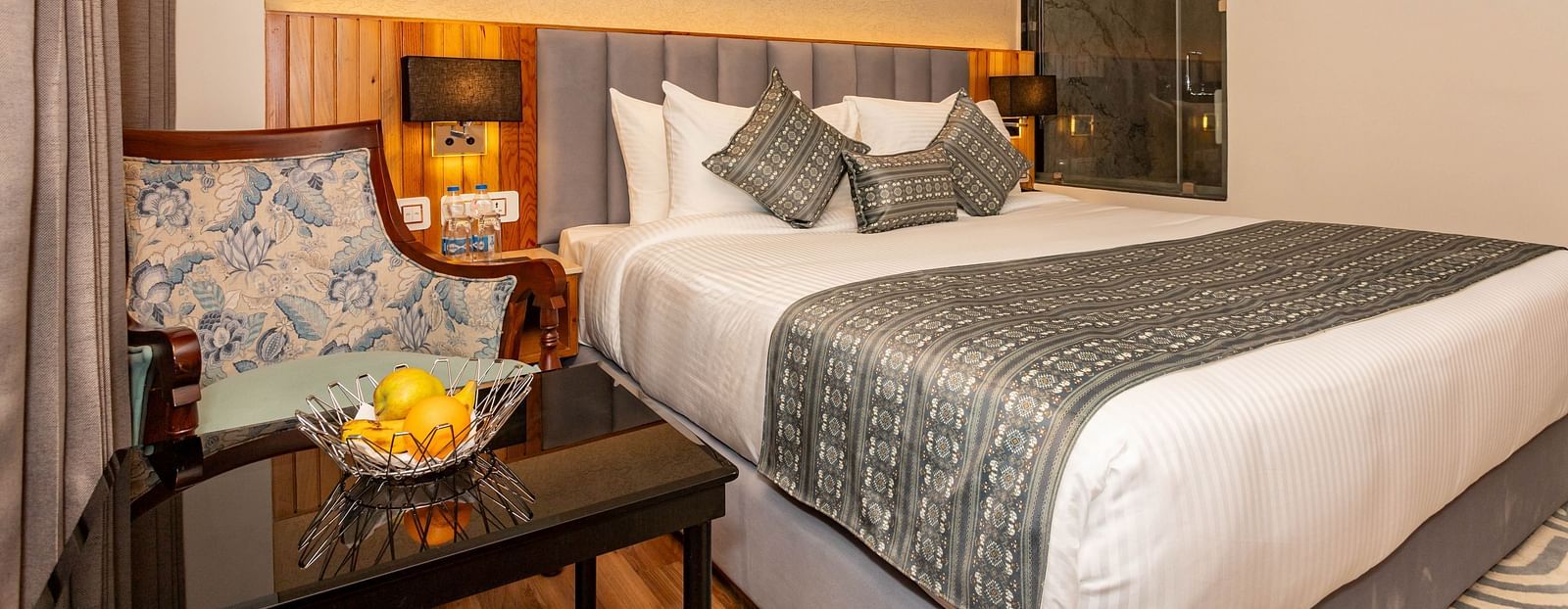 An image of a Superior Room with a bed, bed side table, lamps, and chairs and table - The Belvedere Himalayan Retreat, McLeodganj