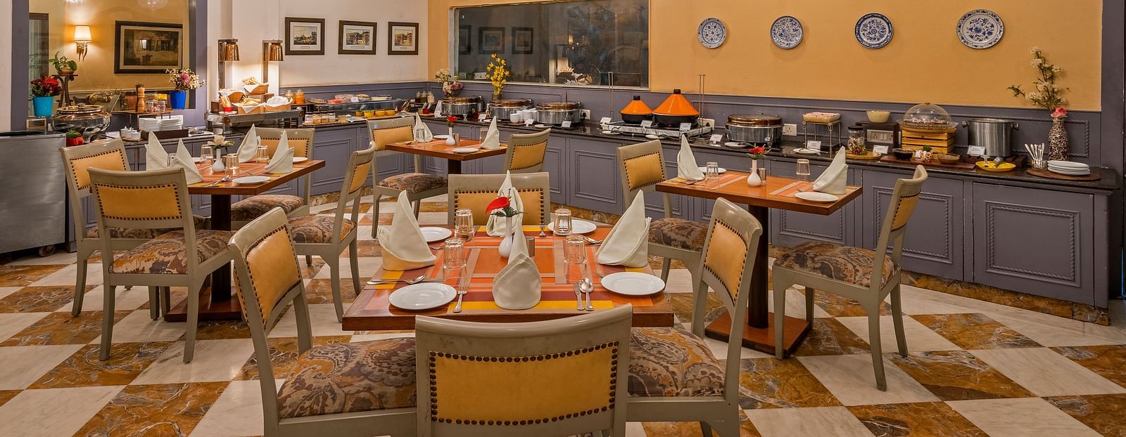 a restaurant with a buffet setting and clusters of tables and chairs - The Manor, Kashipur