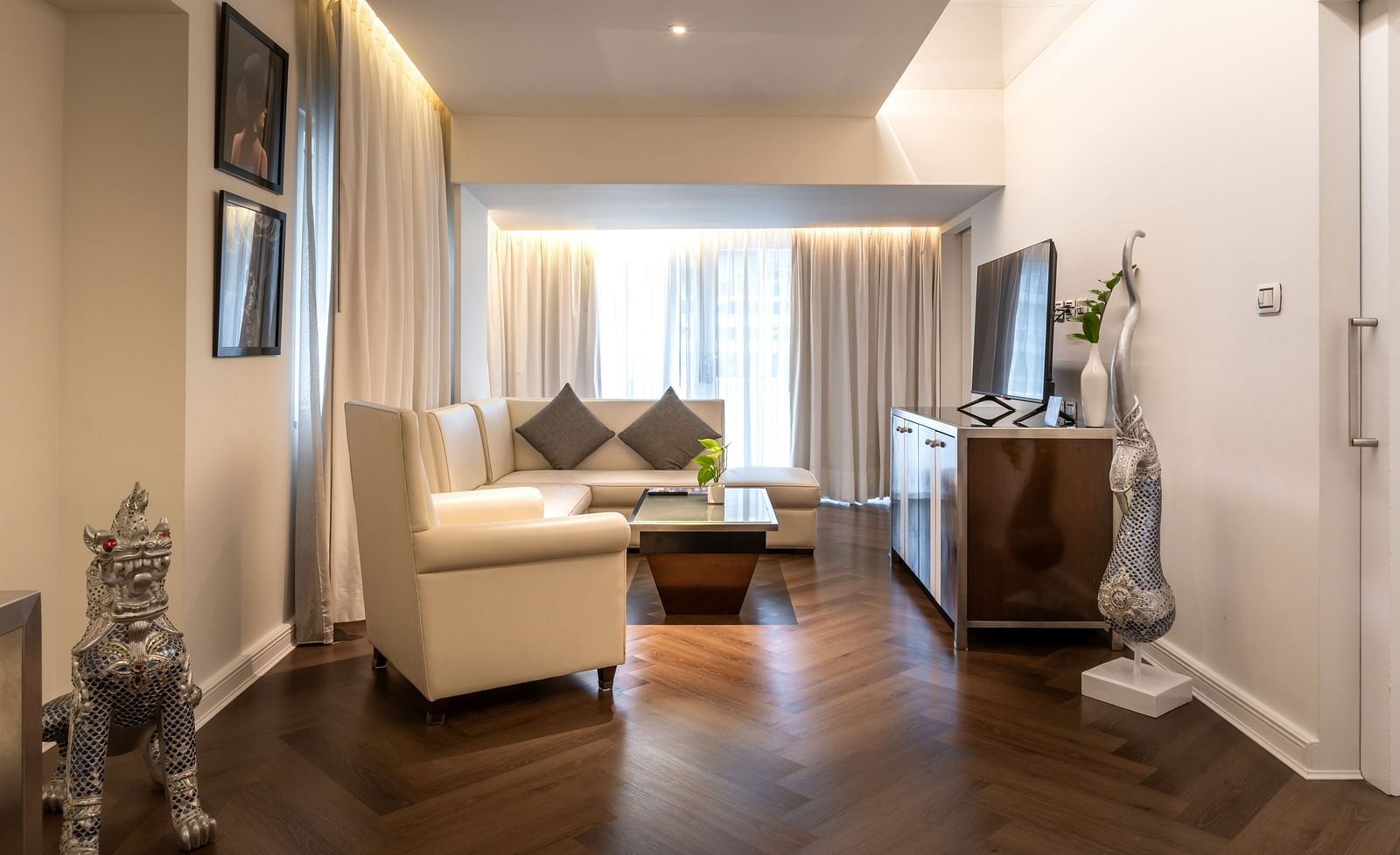 An overview of the living room with a tv, sofas and table in view - Night Hotel Bangkok.