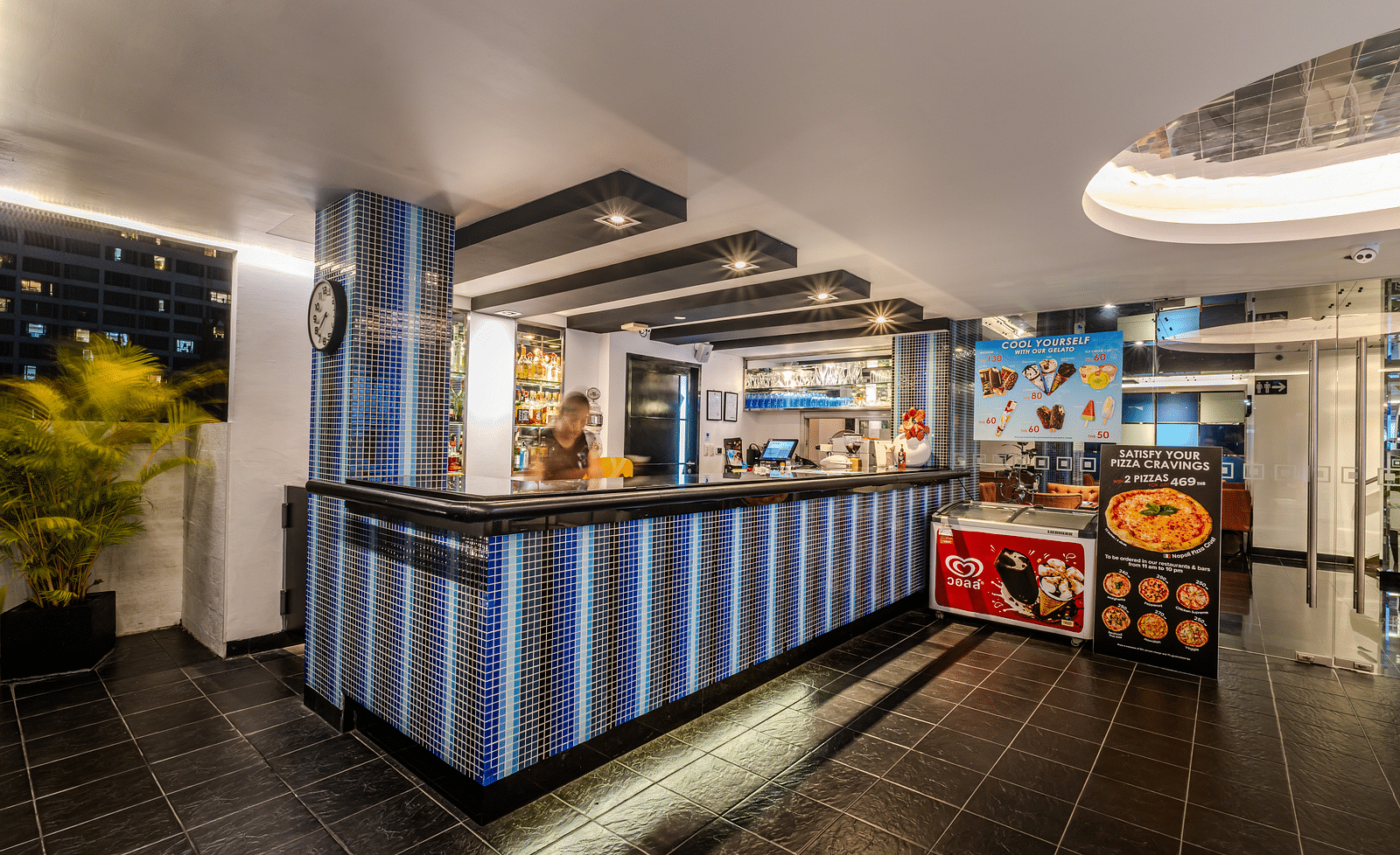 An overview of a bar counter with a staff inside it - Night Hotel Bangkok.