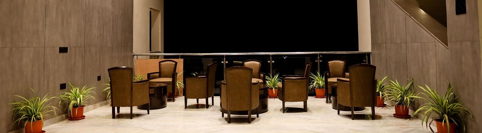 Image of a seating area with tables and chairs with pots on the side at  Calux Grand Baga.
