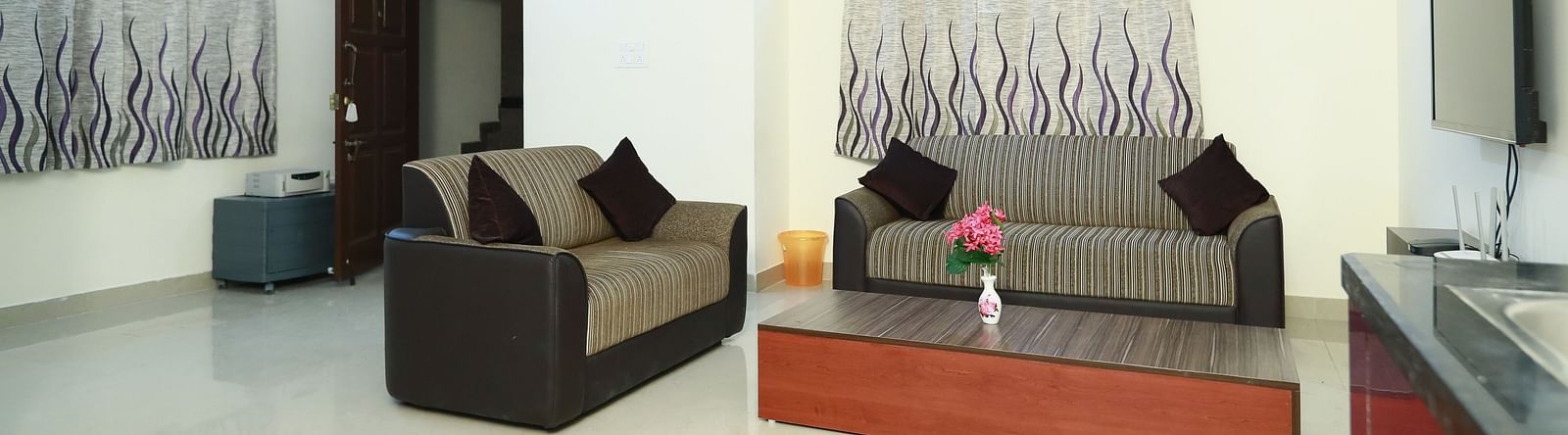 Living area with sofa seating and a coffee table at Tranquil ABS Orchid Serviced Apartments.