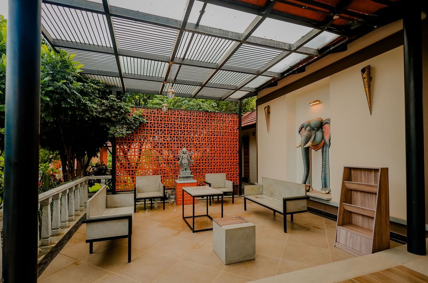 Two people playing table tennis in a well-lit room with large windows at Nirantara Resort & Spa.