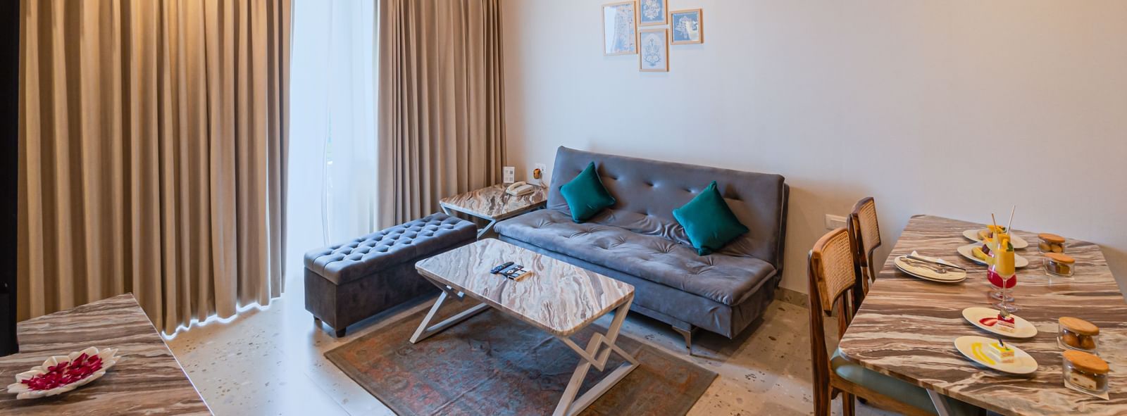 Sajjan Villa at Bamboo Saa Resorts and Spa, Udaipur featuring a seating area with sofa, chairs, and centre table and a dining space.